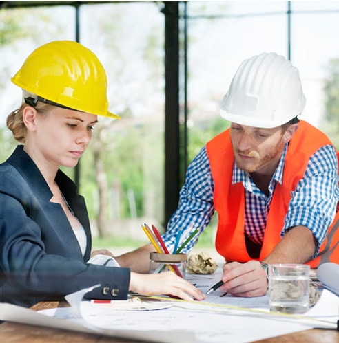 Engineers in safety helmets reviewing plans for municipal infrastructure projects.