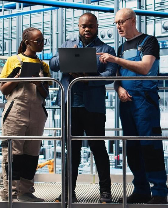 Team of engineers inspecting industrial manufacturing equipment.