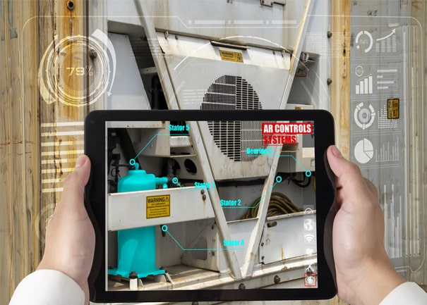 Technician using tablet to monitor industrial equipment and control systems.